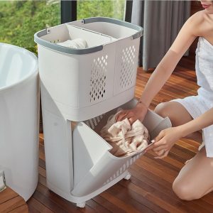 Người phụ nữ đang mở ngăn dưới của giỏ đựng đồ giặt hai tầng bằng nhựa PP.