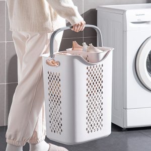 Người dùng xách giỏ đựng quần áo bằng tay cầm tiện lợi.