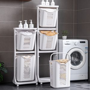 Giỏ đựng quần áo ba tầng đặt cạnh máy giặt, chứa nhiều chai lọ phía trên