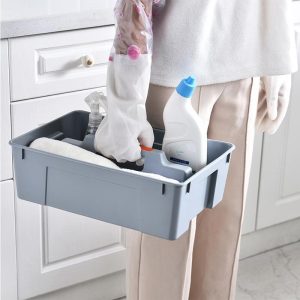 Người dùng cầm hộp đựng nhựa chứa dụng cụ vệ sinh trong nhà bếp