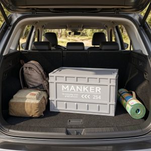 Hộp nhựa xám lớn đặt trong cốp xe ô tô cùng balo và thảm picnic