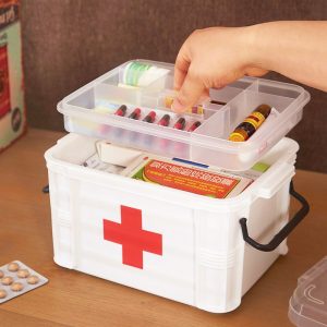 Hộp y tế nhựa với nhiều ngăn, đang được lấy thuốc ra từ khay trên cùng.