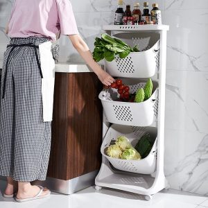 Kệ nhựa 3 tầng màu trắng đựng rau củ quả cạnh bồn rửa, có bánh xe tiện lợi.