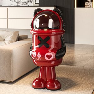 Thùng rác hình gấu panda màu đỏ nổi bật đặt cạnh sofa trong phòng khách.