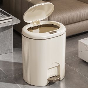 Thùng rác đạp chân màu trắng kem, nắp mở, đặt cạnh sofa.