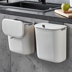 Thùng rác nhựa treo tường cạnh bồn rửa, nắp đóng mở linh hoạt.
