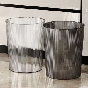 Hai thùng rác nhựa sọc trong suốt và xám đặt cạnh nhau trên nền nhà.