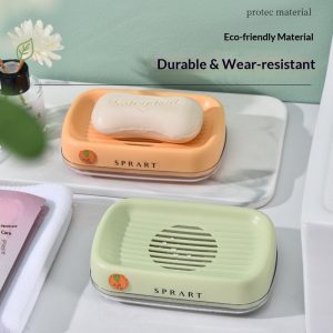 Hai hộp đựng xà phòng màu cam và xanh nhạt đặt trên kệ phòng tắm, có xà phòng bên trong.