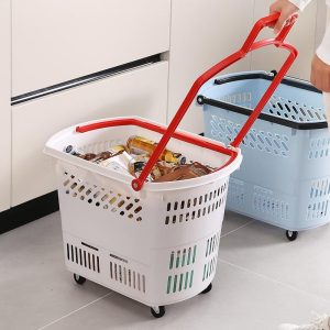 Giỏ nhựa PP đa năng gấp gọn 35L có bánh xe kéo đựng đồ tiện lợi Giỏ nhựa trắng có bánh xe, tay cầm đỏ, chứa đầy đồ dùng trong bếp.