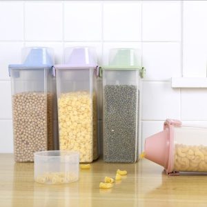Hộp nhựa thực phẩm cao cấp nắp bật kín khí BPA Free 2.5L đa năng Bốn hộp đựng thực phẩm nắp màu pastel, một hộp đang đổ mì ra ngoài.