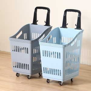 Hai giỏ kéo siêu thị màu xám và xanh nhạt với tay kéo đen, đặt trên sàn gỗ.