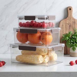 Ba hộp nhựa trong suốt xếp chồng, đựng cà chua, cam và ngô