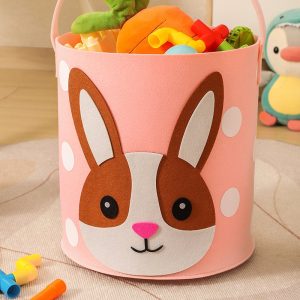 Thùng đựng đồ chơi vải nỉ màu hồng hình thỏ, chứa nhiều đồ chơi bên trong.