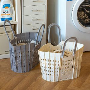 Hai giỏ đựng quần áo bẩn màu xám và trắng đặt cạnh máy giặt.