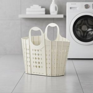 Giỏ nhựa đựng quần áo màu trắng kem đặt trước máy giặt.