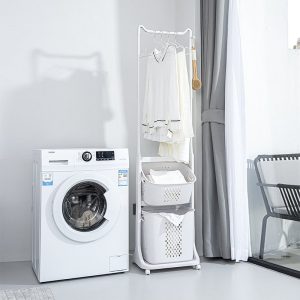 Giỏ đựng đồ giặt đa năng đặt cạnh máy giặt, có giá treo quần áo và hai giỏ đựng.