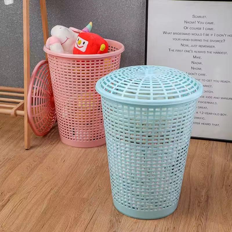 Giỏ đựng quần áo nhựa PP có nắp dung tích lớn đa năng cho gia đình Hai giỏ đựng quần áo màu xanh và hồng có nắp đậy, đặt cạnh tường.