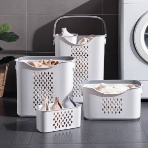 Bốn giỏ đựng quần áo nhựa trắng nhiều kích thước đặt cạnh máy giặt.