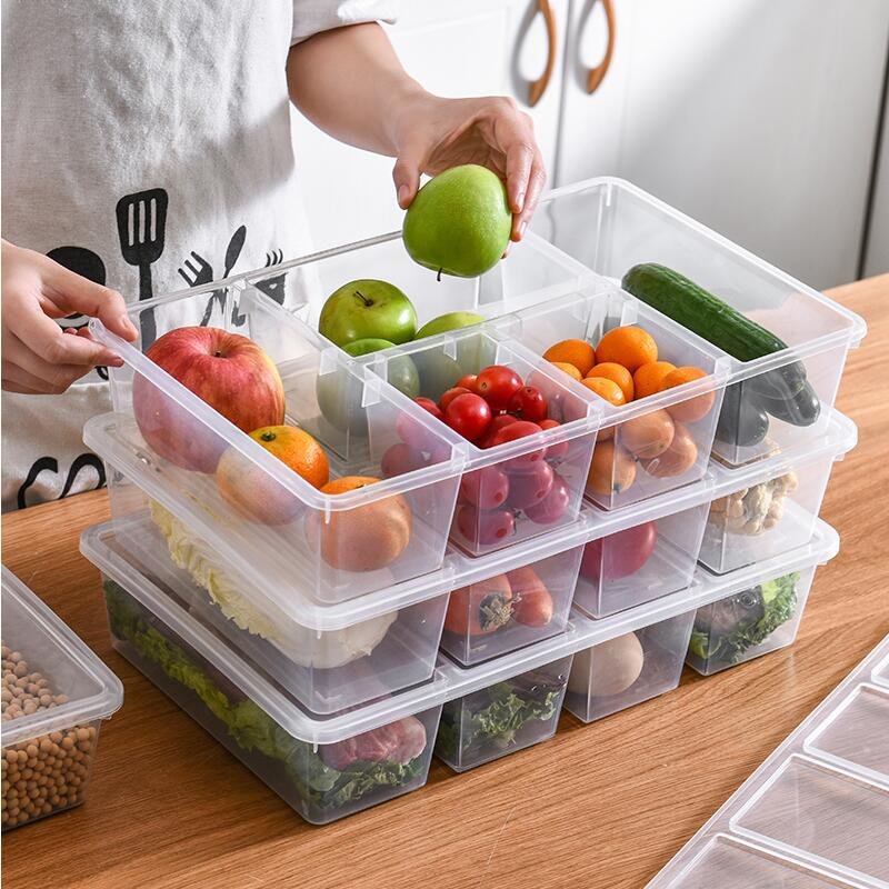 Hộp nhựa PP đựng thực phẩm tủ lạnh nhiều ngăn nắp trong suốt xếp chồng Hộp đựng thực phẩm trong suốt, nhiều ngăn, đang được xếp chồng và đựng trái cây, rau củ.