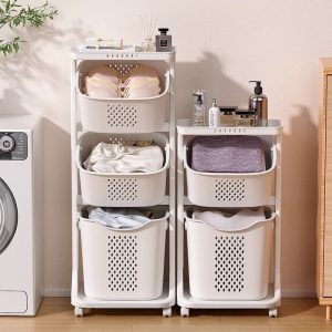 Giỏ đựng đồ giặt nhiều tầng màu trắng, trên cùng để các chai lọ và vật dụng nhỏ.