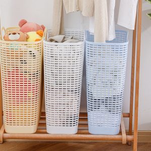 Ba giỏ đựng quần áo màu vàng, trắng, xanh dương đặt cạnh nhau, đựng đồ chơi và quần áo.