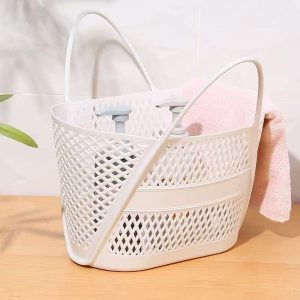 Giỏ nhựa trắng đặt trên bàn, bên trong có khăn tắm.