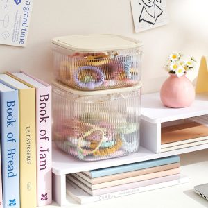 Hai hộp nhựa xếp chồng lên nhau gọn gàng trên bàn học.