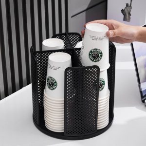 Người dùng lấy cốc giấy từ kệ đựng cốc nhựa màu đen.