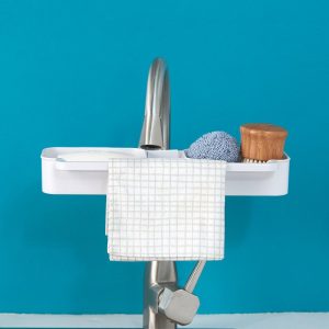 Kệ nhựa trắng treo trên vòi, đựng bàn chải và khăn lau