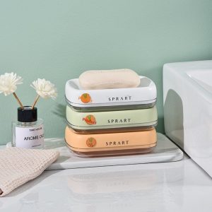 Hộp đựng xà phòng nhựa dày hai lớp thoát nước bảo quản phòng tắm Ba hộp đựng xà phòng màu trắng, xanh nhạt và cam xếp chồng lên nhau cạnh bồn rửa.