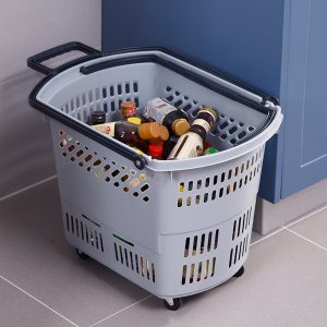 Giỏ kéo màu xám đặt trên sàn, đựng nhiều chai lọ và đồ dùng.
