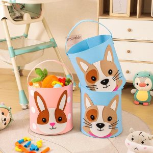 Hai thùng đựng đồ chơi vải nỉ màu hồng và xanh, họa tiết thỏ và chó, đặt trong phòng trẻ em.