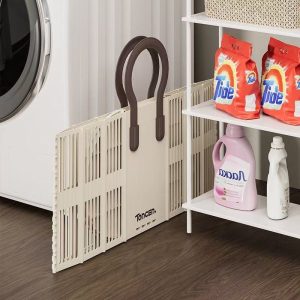Giỏ đựng đồ màu kem được gấp gọn, đặt sát máy giặt và kệ để tiết kiệm diện tích.