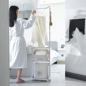 Người phụ nữ treo khăn lên giá, giỏ đựng đặt phía dưới tiện lợi.