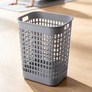 Giỏ nhựa xám đặt trên sàn gỗ, ánh sáng tự nhiên chiếu vào.