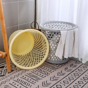 Giỏ màu vàng nằm ngang và giỏ màu xám đặt đứng trong phòng tắm.