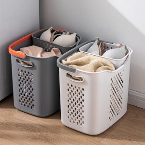 Hai giỏ đựng quần áo màu xám và trắng đặt sát tường, bên trong phân loại quần áo và đồ lót.