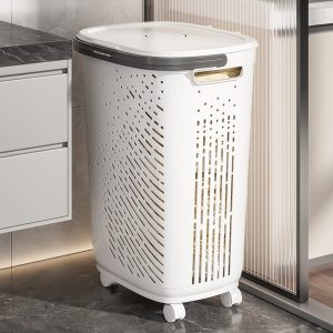 Giỏ đựng quần áo nhựa PP có bánh xe nắp đậy tiện lợi cho gia đình Giỏ đựng quần áo nhựa màu trắng, nắp xám, đặt cạnh tủ bếp.