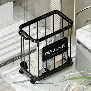 Giỏ đựng đồ màu đen đặt trong phòng ngủ, bên trong có quần áo.
