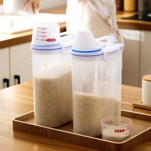 Hai hộp nhựa đựng gạo với nắp đo, đặt trên khay gỗ trong không gian bếp sáng sủa.