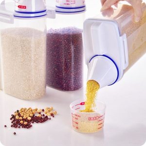 Hộp nhựa đang rót ngũ cốc vào cốc đo, thể hiện miệng rót tiện lợi.