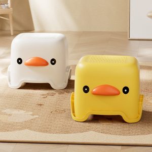 Hai ghế đẩu hình vịt màu trắng và vàng đặt cạnh nhau.