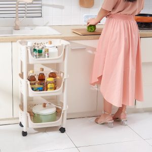 Kệ nhựa 3 tầng đặt cạnh bếp, chứa chai lọ và nồi
