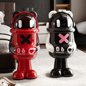 Hai thùng rác hình gấu panda màu đỏ và đen trắng đặt trong phòng ngủ hiện đại.