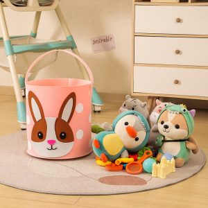 Giỏ đựng đồ chơi hình thỏ màu hồng bên cạnh các thú nhồi bông và đồ chơi trẻ em.