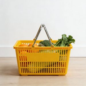 Giỏ nhựa màu vàng chứa rau củ và trái cây, đặt trên sàn nhà.