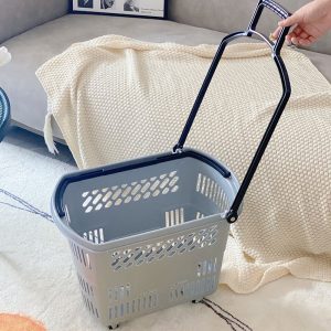 Giỏ nhựa xám với tay kéo dài màu đen, đặt trên thảm.
