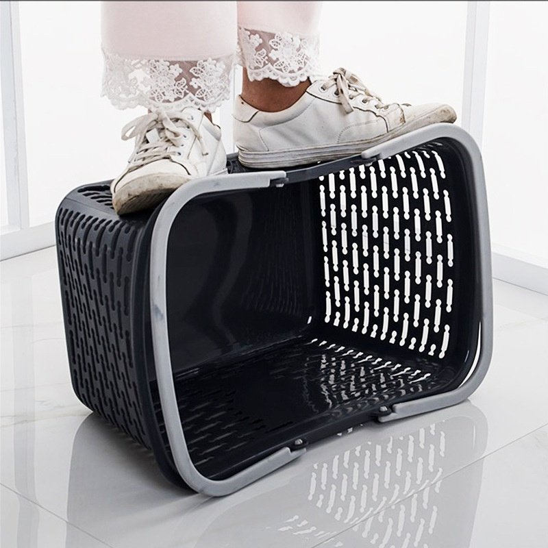 Giỏ xách nhựa PP 2 quai đa năng 25L đựng rau củ quả, đồ dùng gia đình Một người đứng lên giỏ nhựa, thể hiện độ bền và chắc chắn của sản phẩm.