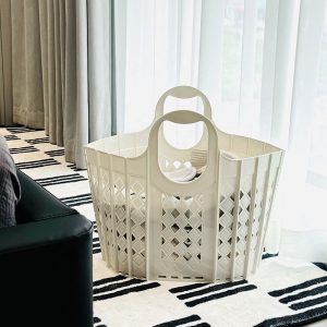 Giỏ nhựa trắng đựng đồ đặt trên thảm trong phòng khách.