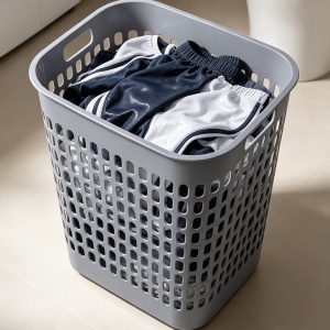 Giỏ nhựa xám chứa đầy quần áo, nhìn rõ thiết kế lỗ thoáng khí và tay cầm.